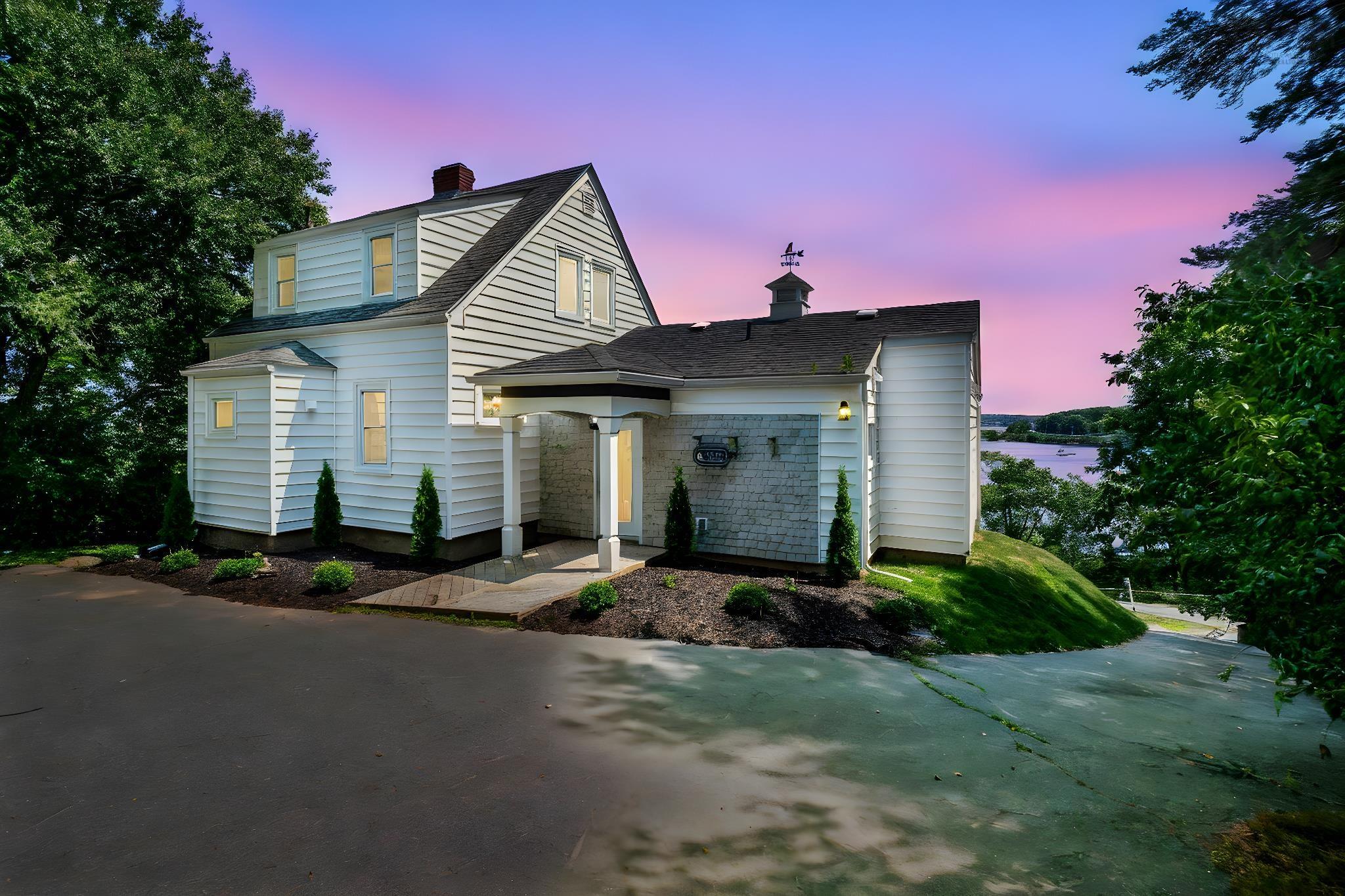 View of front of house featuring a chimney and a shingled roof
