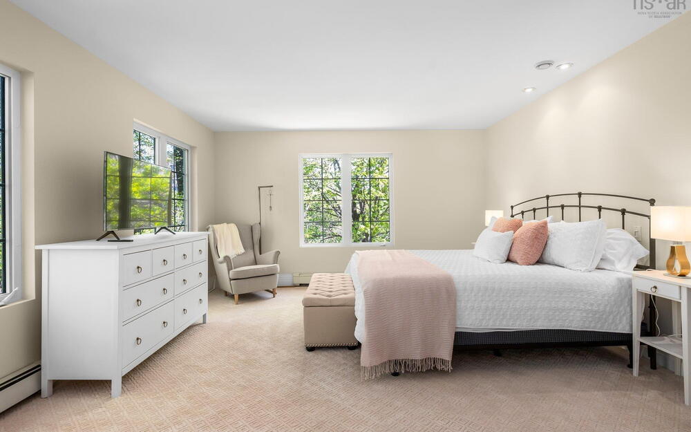 Bedroom featuring baseboard heating, light carpet, and recessed lighting