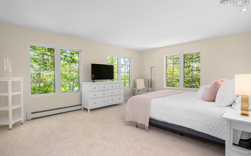 Bedroom with baseboard heating, multiple windows, light carpet, and recessed lighting