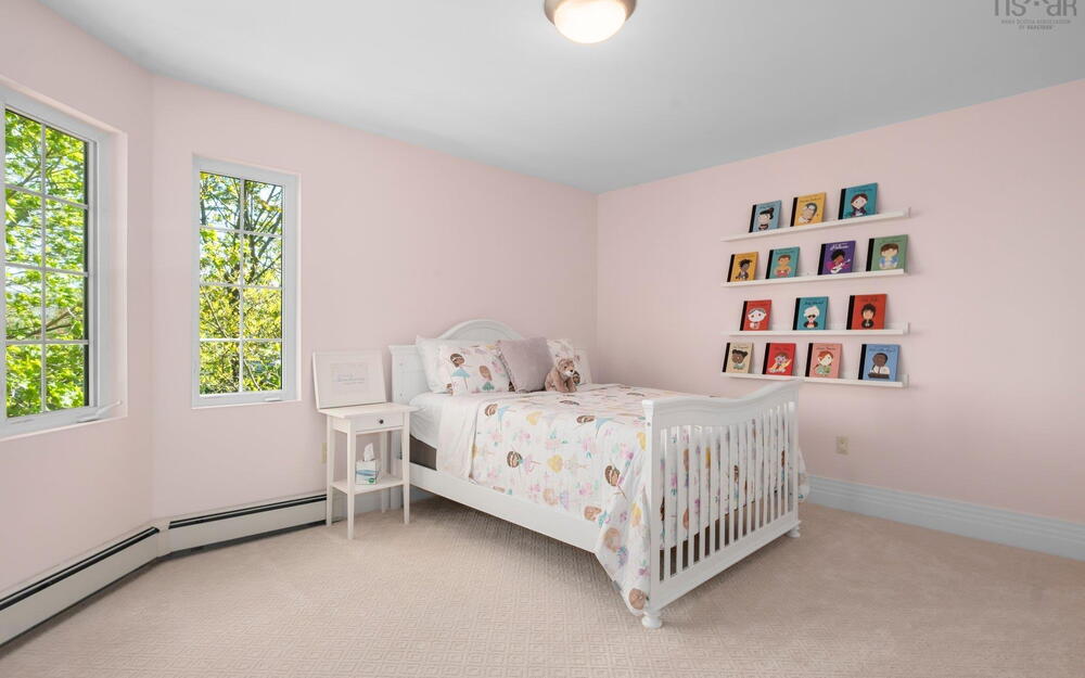 Carpeted bedroom with multiple windows, baseboard heating, and baseboards