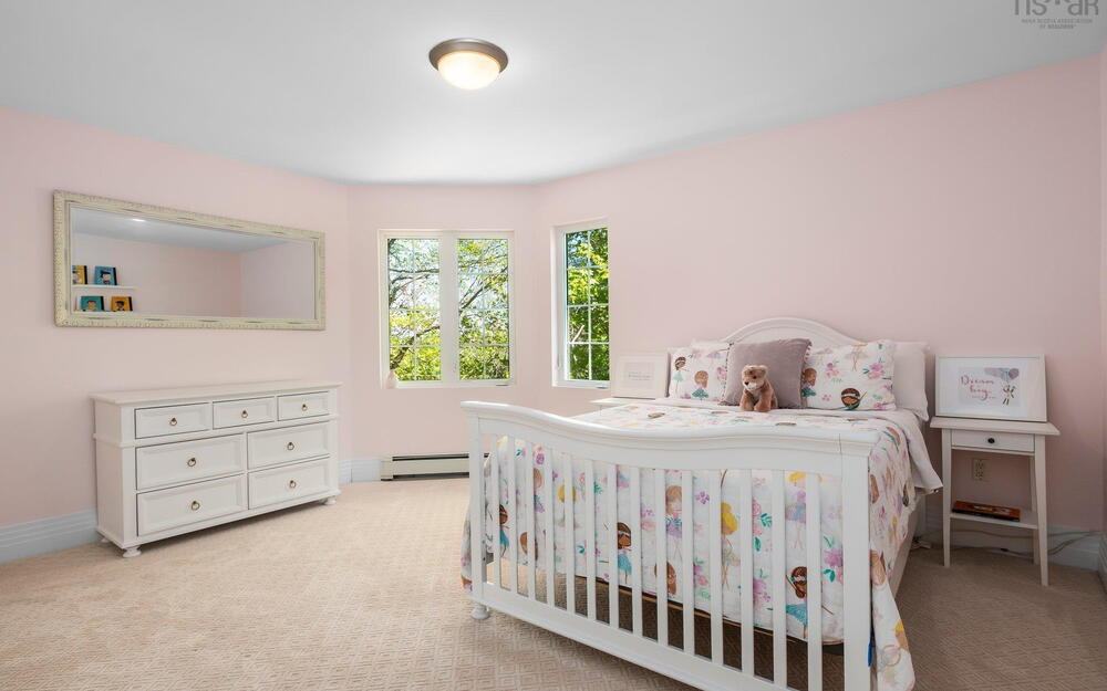 Carpeted bedroom with a baseboard radiator and baseboards