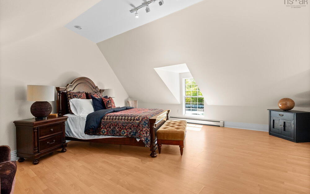 Bedroom featuring vaulted ceiling, a baseboard heating unit, light wood finished floors, and baseboards