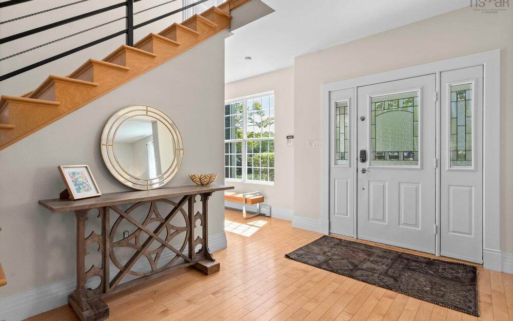 Foyer entrance featuring baseboards, wood finished floors, and a baseboard heating unit