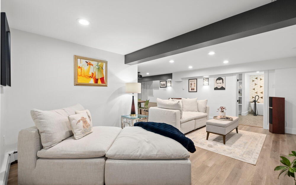 Living area with recessed lighting, light wood-type flooring, and a baseboard heating unit