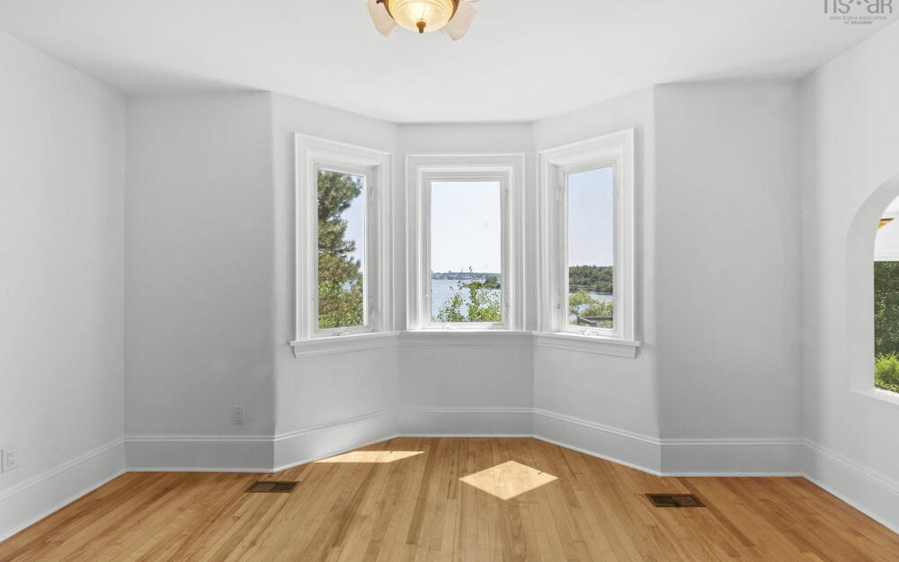 Empty room featuring light wood finished floors and arched walkways