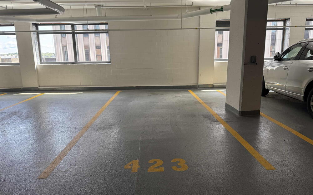 Dedicated parking space featuring painted floor markings and perimeter walls