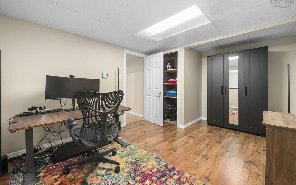 Room featuring wood-finish flooring, neutral wall tones, and a drop ceiling with recessed lighting