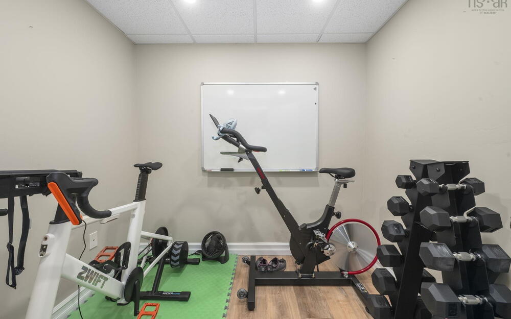 Dedicated exercise space featuring recessed lighting, a drop ceiling, wood-finish flooring, and light-toned wall paint