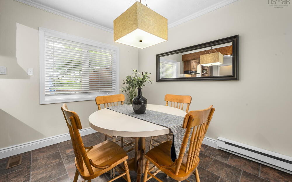 Dining area featuring tiled flooring, a rectangular window with blinds, and crown molding