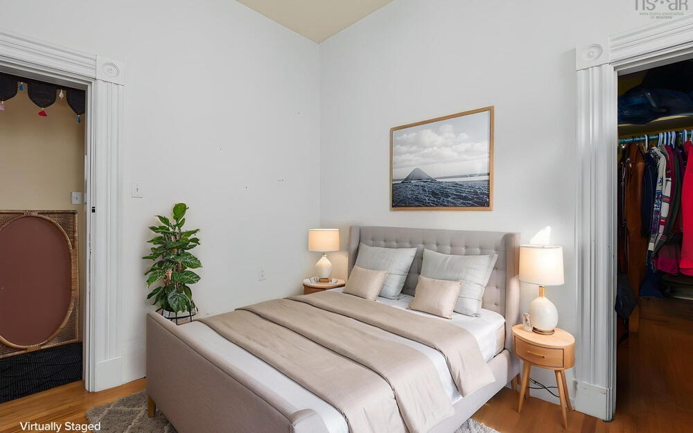 Interior room featuring high ceilings, hardwood flooring, and decorative crown block molding above the doorways